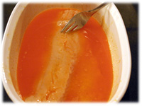dipping fish in franks red hot sauce